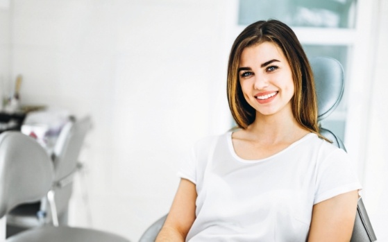 Young woman in dental chair smiling thanks to restorative dentistry in Fresno