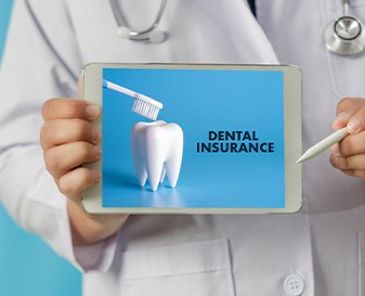 Dentist holding tablet that reads “Dental Insurance”